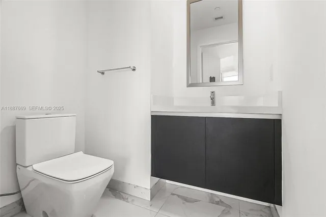 a white toilet sitting next to a bathroom sink