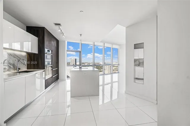 a large kitchen with a large counter top stainless steel appliances and cabinets
