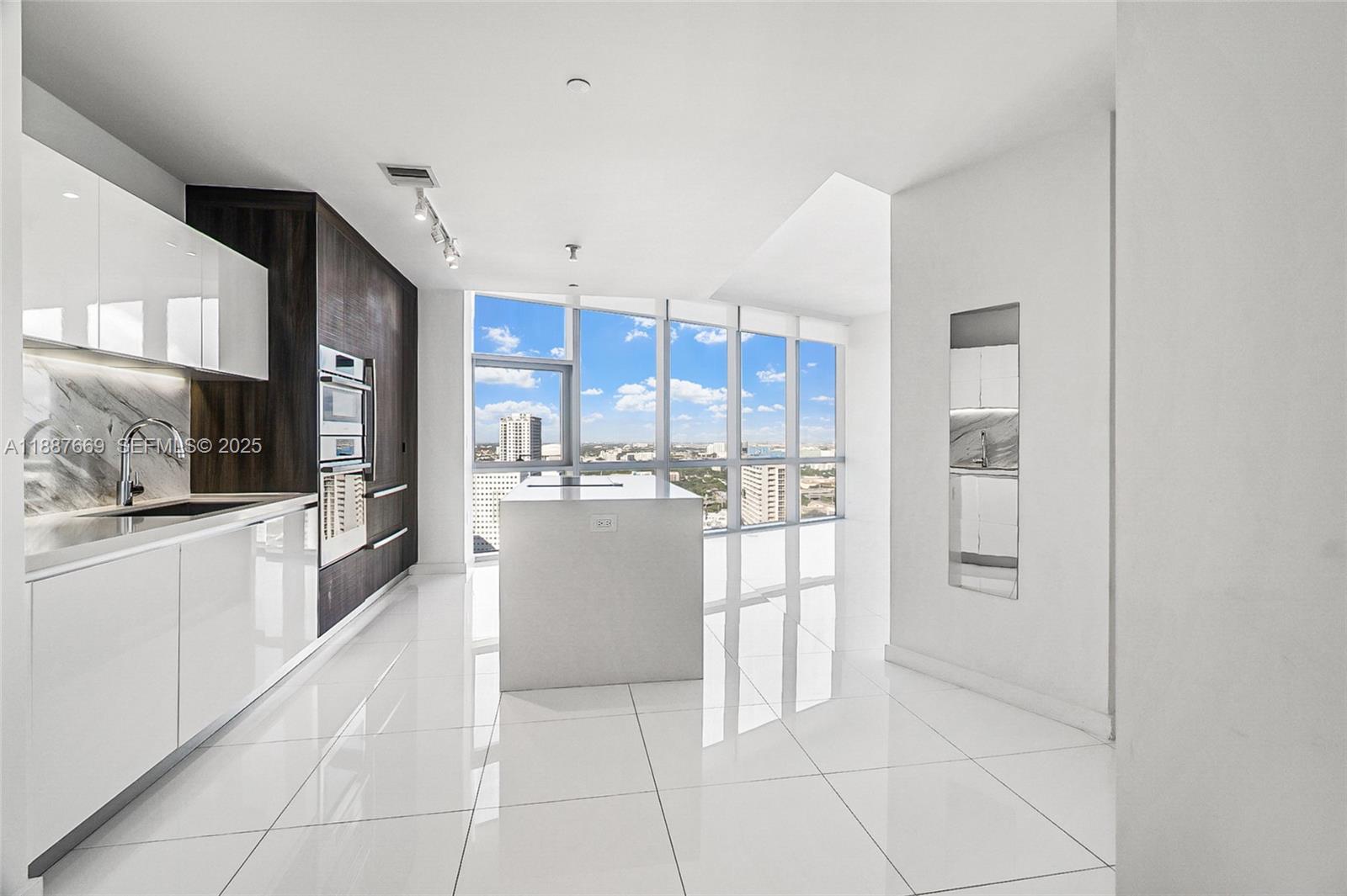 851 Northeast 1st Avenue, Unit 2802 Miami, FL 33132 - Photo 16 of 50 a large kitchen with a large counter top stainless steel appliances and cabinets
