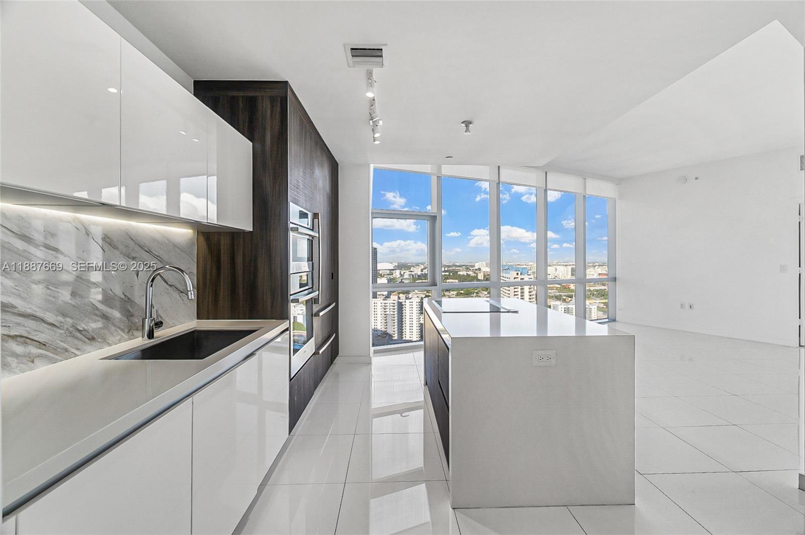 851 Northeast 1st Avenue, Unit 2802 Miami, FL 33132 - Photo 5 of 50 a view of a kitchen with granite countertop a large window