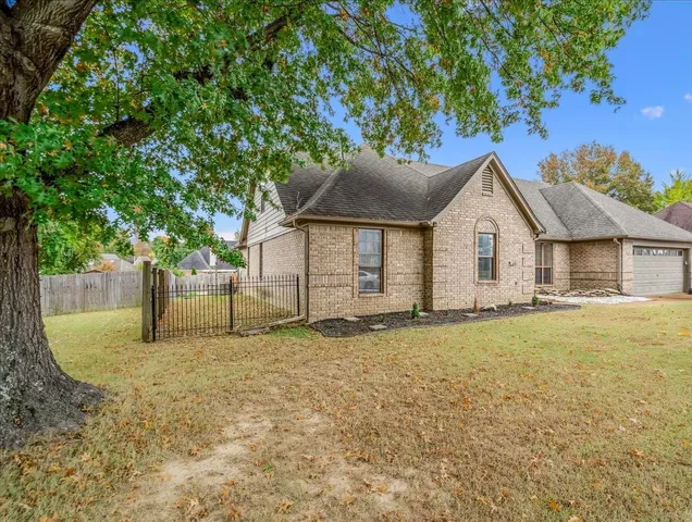 a view of an empty room with wooden floor fireplace and a window
