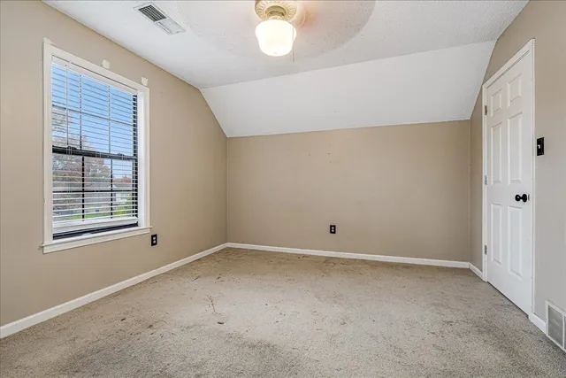 a view of a room with a ceiling fan and a window