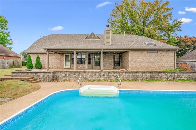a view of a house with pool and a yard