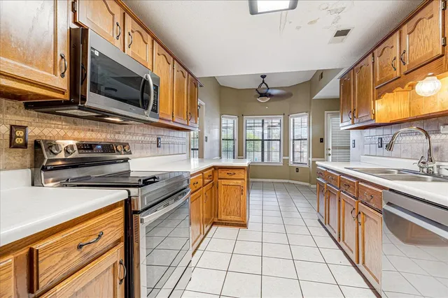a kitchen with stainless steel appliances granite countertop a stove a sink and a microwave