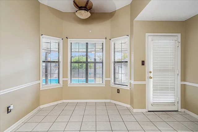 a view of an empty room with window and cabinet