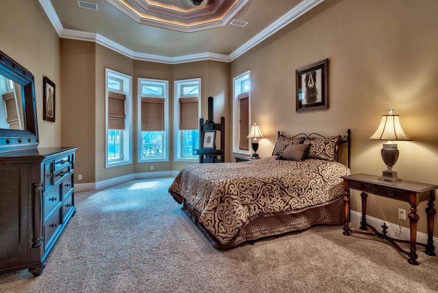 2918 Sand Pine Road Miramar Beach, FL 32550 - Photo 8 of 25 a spacious bedroom with a bed a table and large mirror