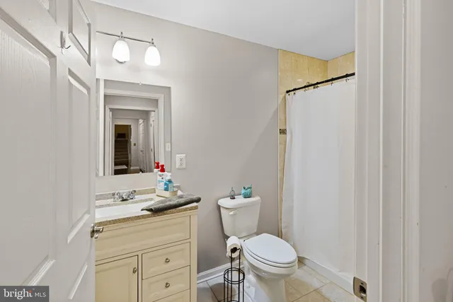 a bathroom with a granite countertop sink toilet mirror and a shower