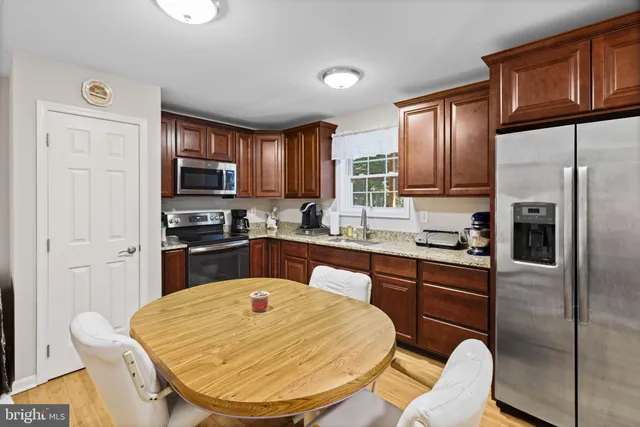 a kitchen with stainless steel appliances granite countertop a refrigerator sink stove microwave and cabinets