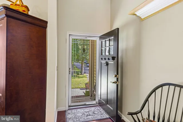a view of a hallway with wooden floor and a bathroom