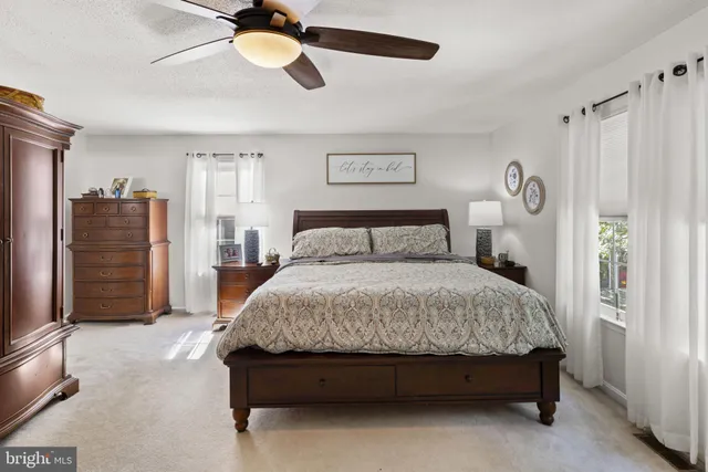 a spacious bedroom with a bed and a chandelier