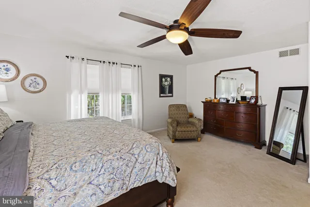 a bedroom with a bed dresser and a large window