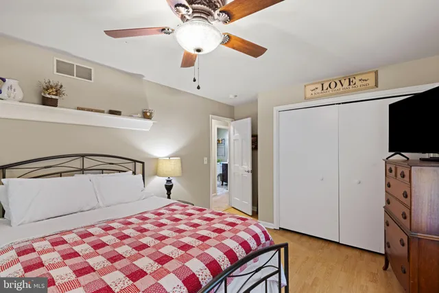 a bedroom with a bed and a flat tv screen on the dresser