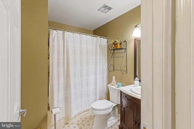 a bathroom with a granite countertop toilet and a sink