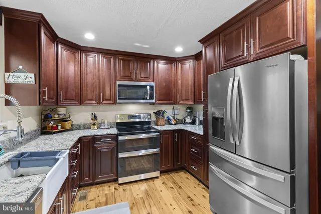 a kitchen with granite countertop stainless steel appliances and wooden cabinets