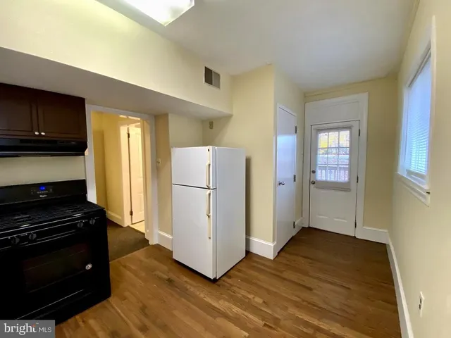a kitchen with a refrigerator and a stove top oven