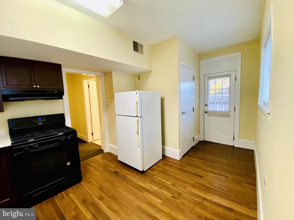1415 North Harrison Street, Unit 2 Wilmington, DE 19806 - Photo 6 of 21 a kitchen with a refrigerator and a stove top oven