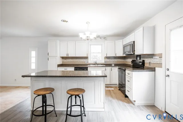 a kitchen with stainless steel appliances granite countertop a white cabinets and a stove top oven