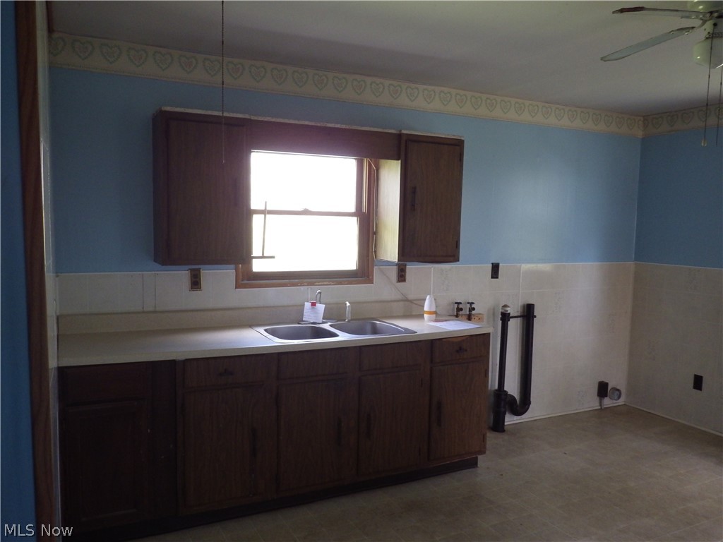 1446 Randolph Road Mogadore, OH 44260 - Photo 5 of 14 Kitchen with backsplash, sink, ceiling fan, and light tile floors