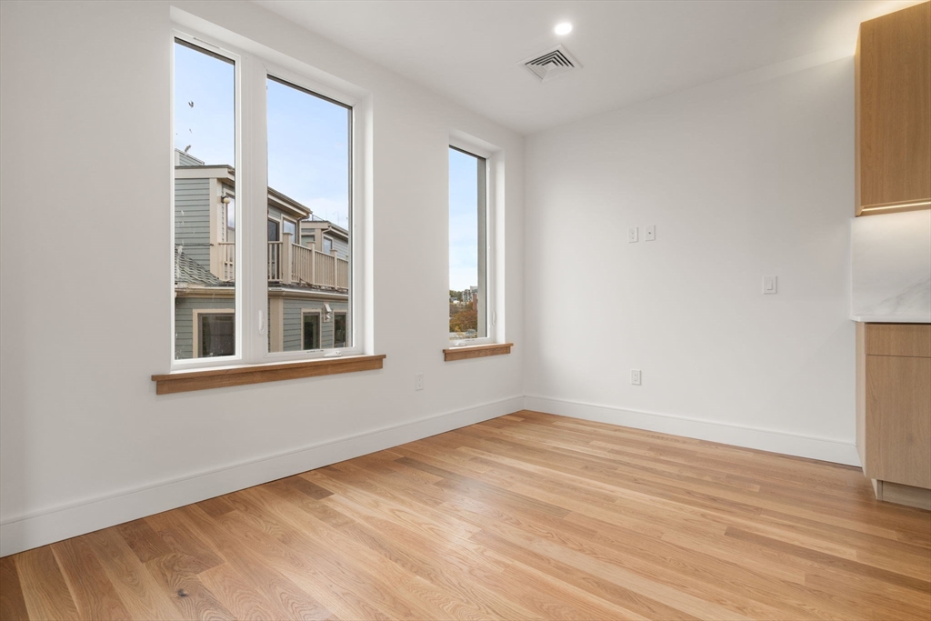 58 Kent, Unit 304 Brookline, MA 02445 - Photo 5 of 19 a view of an empty room with wooden floor and a window