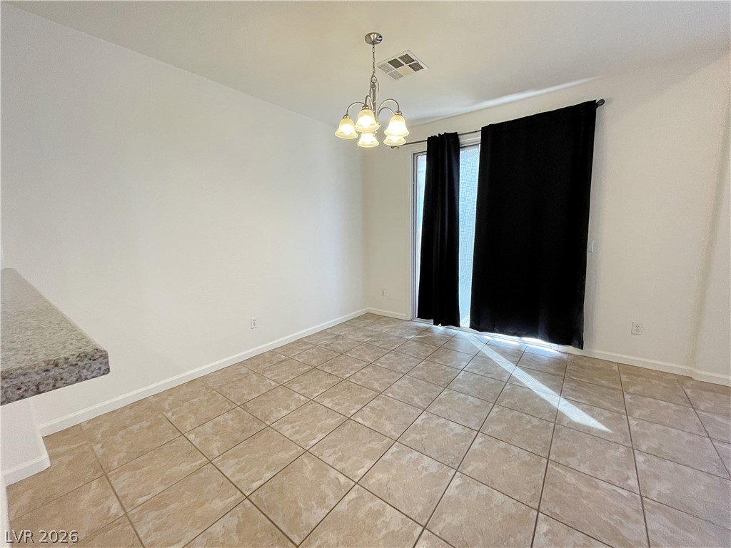 691 Principle Point Avenue Henderson, NV 89012 - Photo 10 of 30 Dining area with tiled floors, a chandelier, and convenient exterior access.