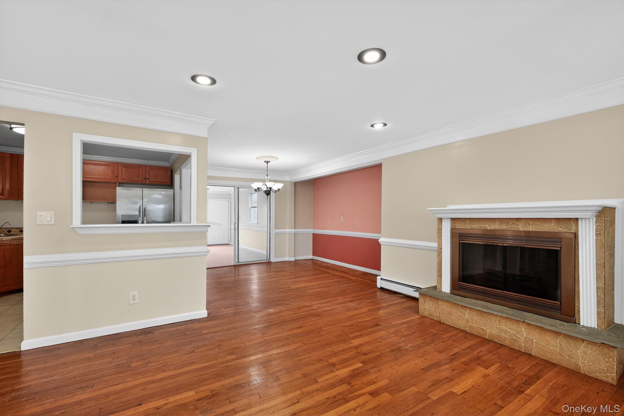 138 Spring Street Massapequa, NY 11758 - Photo 7 of 45 an empty room with wooden floor fireplace and windows