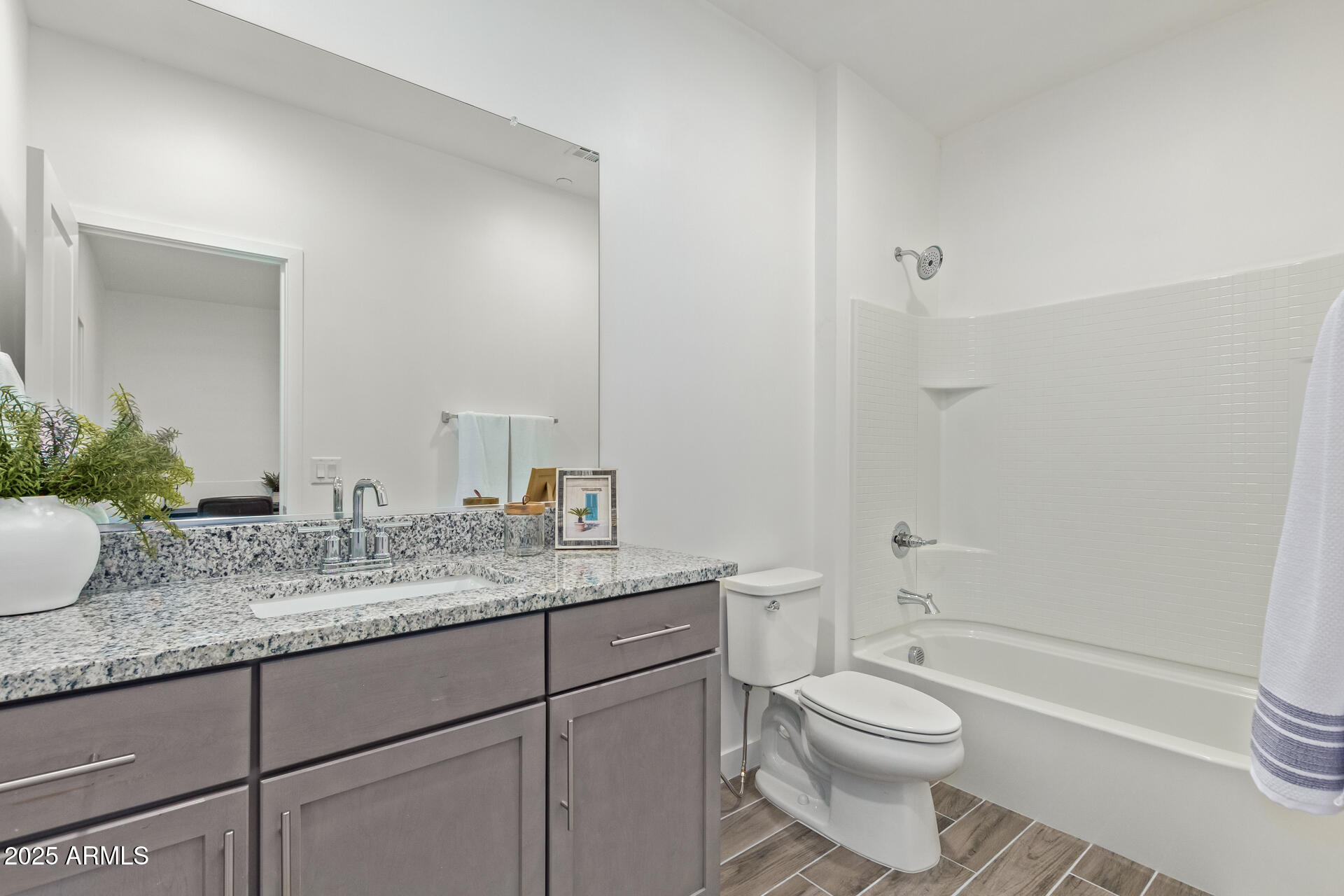 3230 East Thomas Road, Unit 184 Mesa, AZ 85213 - Photo 22 of 30 a bathroom with a granite countertop toilet sink and mirror