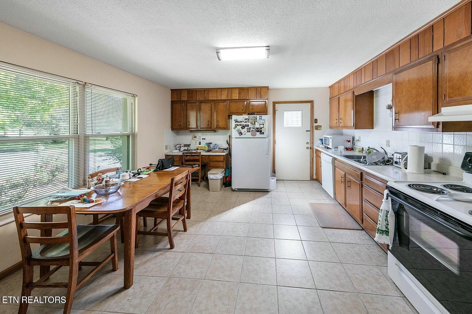 714 Broome Road Northwest, Unit B Knoxville, TN 37909 - Photo 5 of 10 a kitchen with a table chairs sink and cabinets