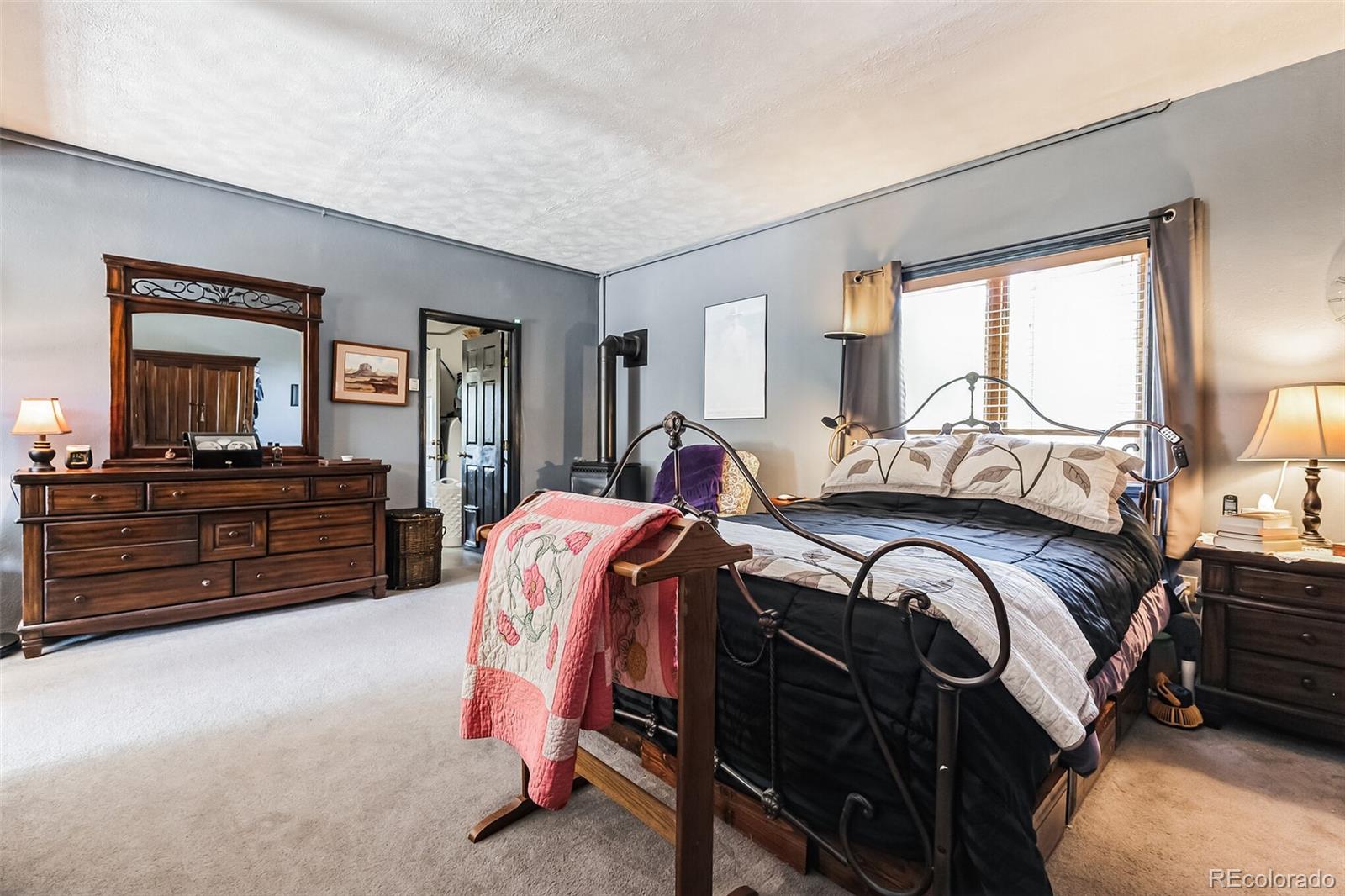 7882 Combs Road Fort Garland, CO 81133 - Photo 26 of 43 a bedroom with a bed and dresser with mirror
