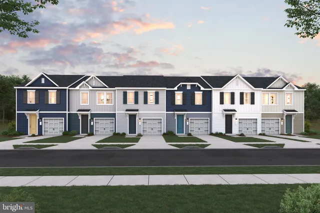 a front view of residential houses with yard and green space