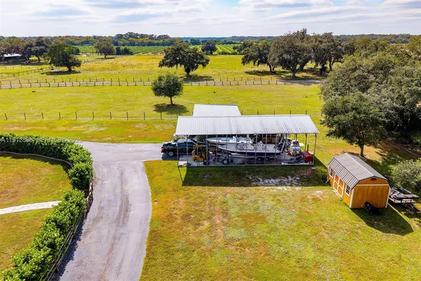 a kitchen with stainless steel appliances granite countertop a stove a sink dishwasher a refrigerator and wooden cabinets with wooden floor