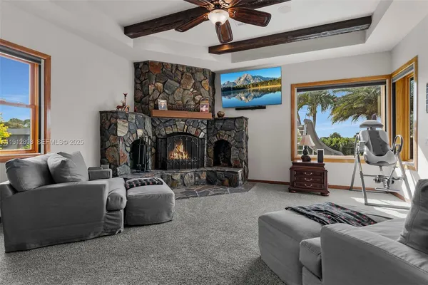 a living room with fireplace furniture and a large window