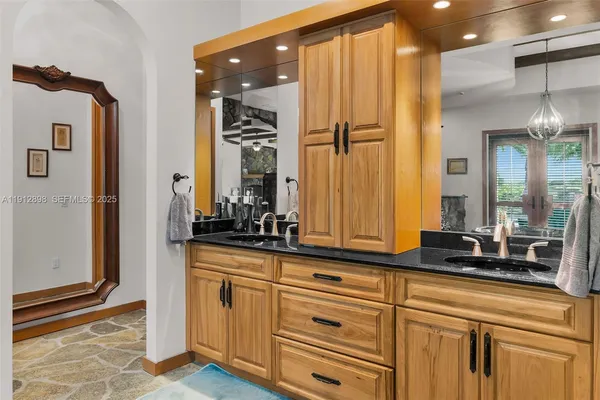 a kitchen with stainless steel appliances granite countertop a sink a stove cabinets counter space and a window