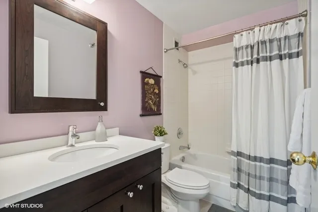 a bathroom with a double vanity sink toilet and shower