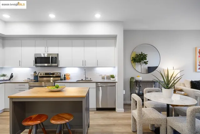 a kitchen with a stove a sink and a dining table with kitchen view