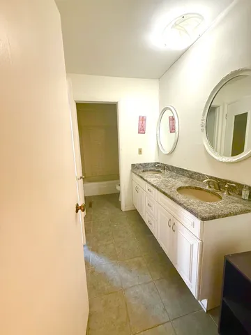 a spacious bathroom with a granite countertop sink and a mirror