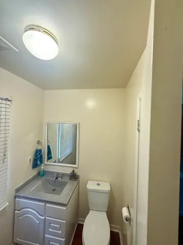 a bathroom with a toilet sink vanity and mirror