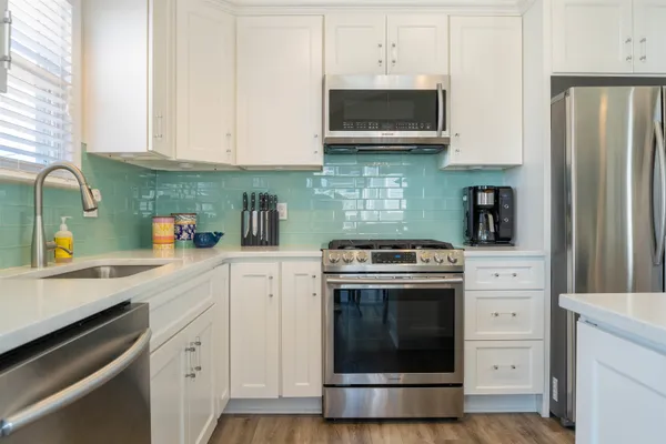 a kitchen with cabinets stainless steel appliances and a sink