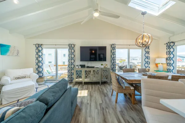 a living room with furniture a large window and wooden floor