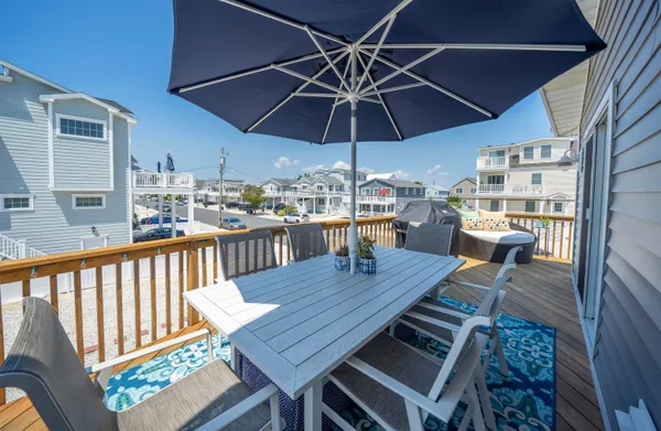 a view of a roof deck with table and chairs under an umbrella
