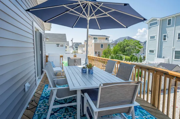 a view of a roof deck with table and chairs under an umbrella