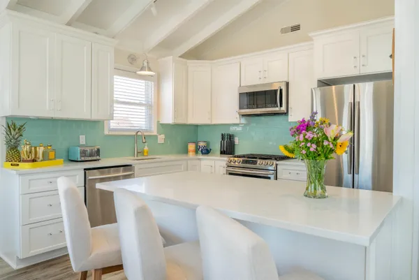 a kitchen with granite countertop a sink stainless steel appliances and cabinets