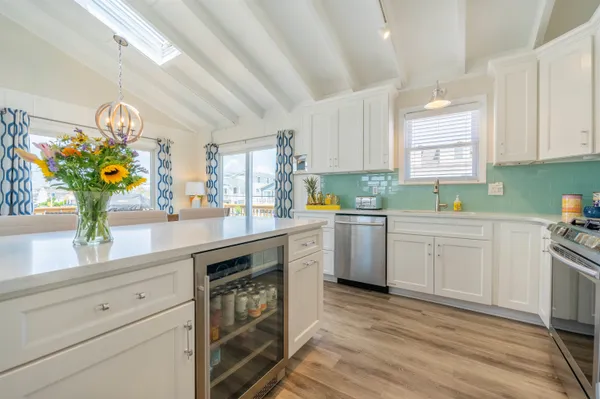 a kitchen with granite countertop stainless steel appliances a sink window and cabinets