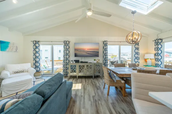 a living room with furniture a large window and wooden floor