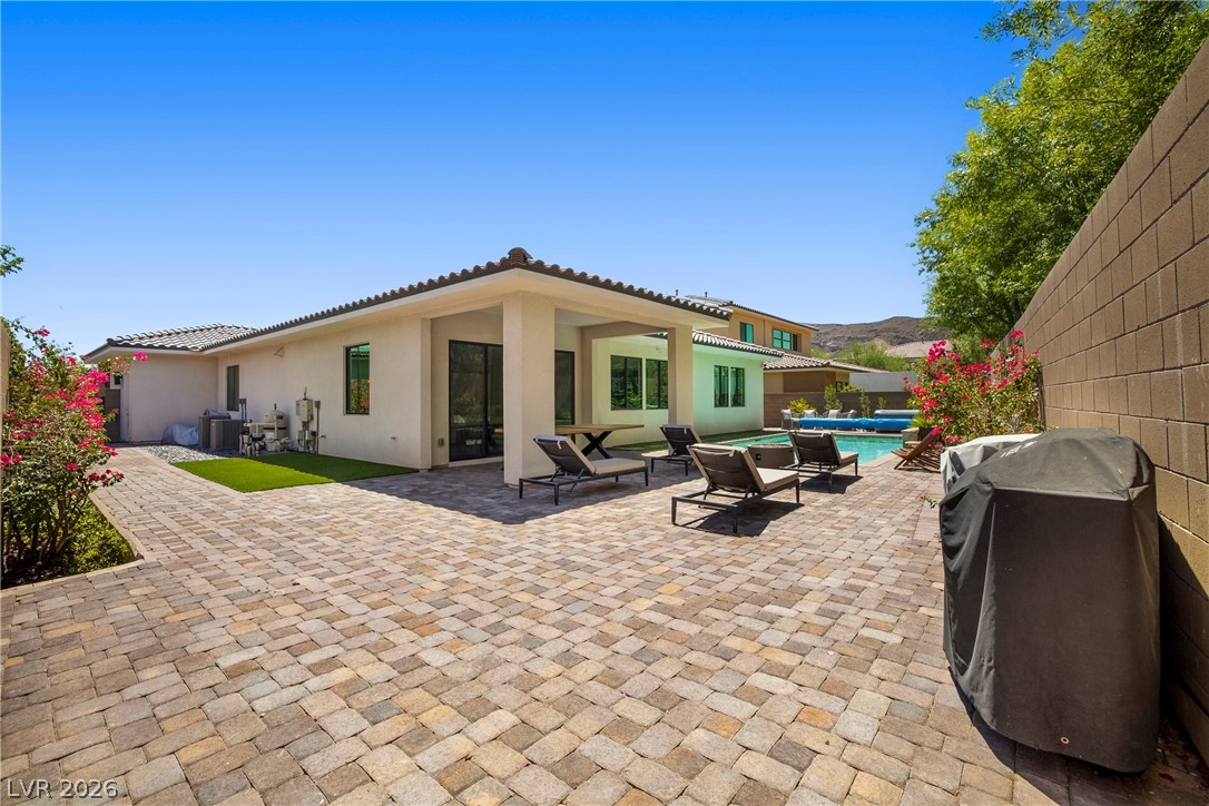 45 Garibaldi Way Henderson, NV 89011 - Photo 38 of 74 A private outdoor space with a tiled patio and a refreshing pool, perfect for leisure.