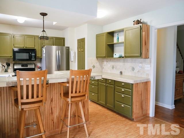 2300 Rolesville Road Wake Forest, NC 27587 - Photo 10 of 24 a kitchen with stainless steel appliances kitchen island granite countertop a refrigerator a stove top oven and a sink