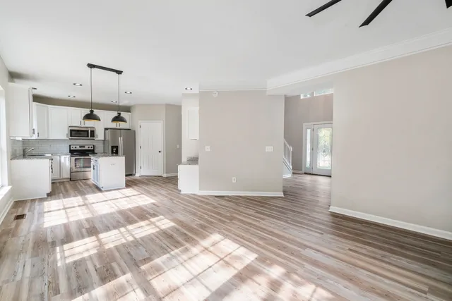a view of a kitchen with wooden floor and electronic appliances