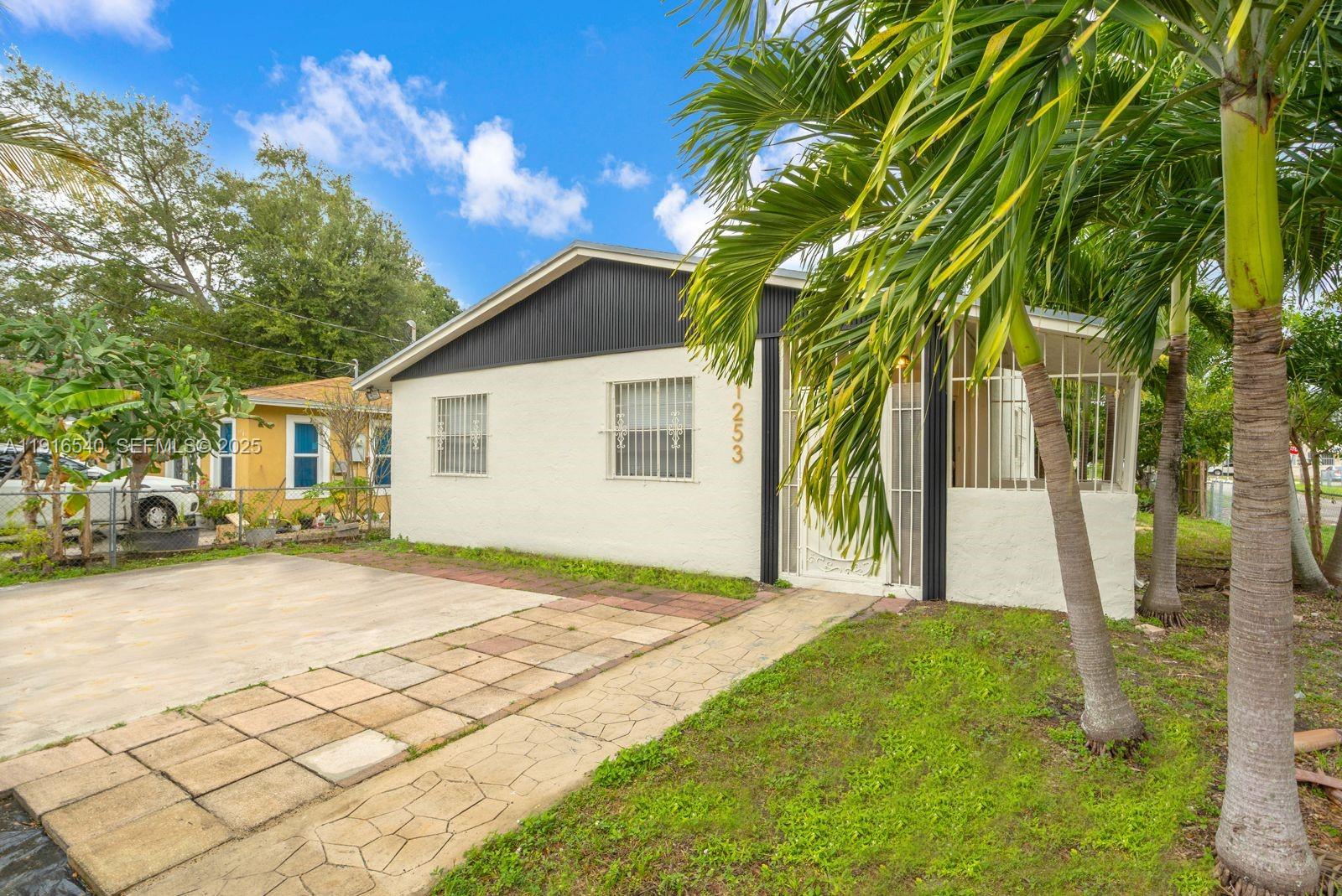 1253 Northwest 44th Street Miami, FL 33142 - Photo 1 of 25 a front view of a house with a yard