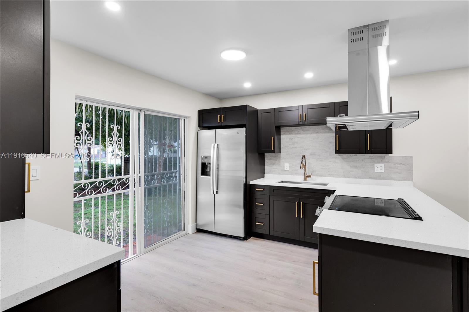 1253 Northwest 44th Street Miami, FL 33142 - Photo 3 of 25 a kitchen with stainless steel appliances a stove a refrigerator a sink and a oven