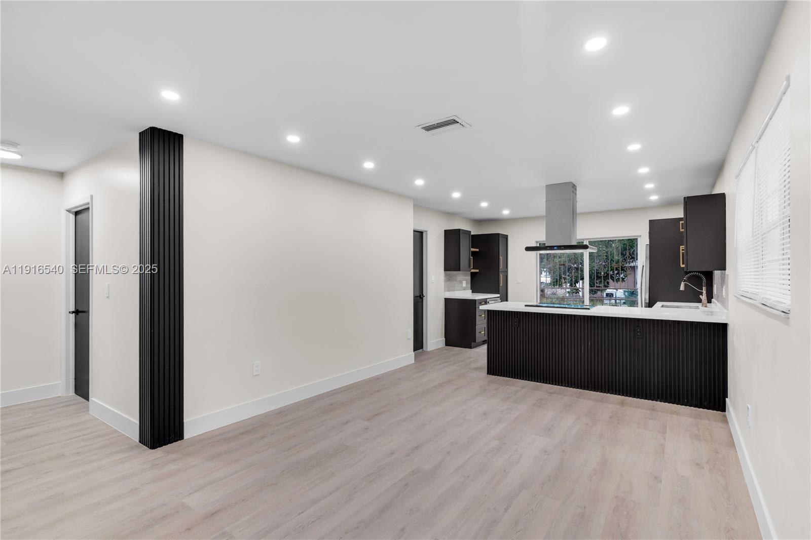 1253 Northwest 44th Street Miami, FL 33142 - Photo 5 of 25 a large kitchen with stainless steel appliances kitchen island a large counter top and a wooden floors