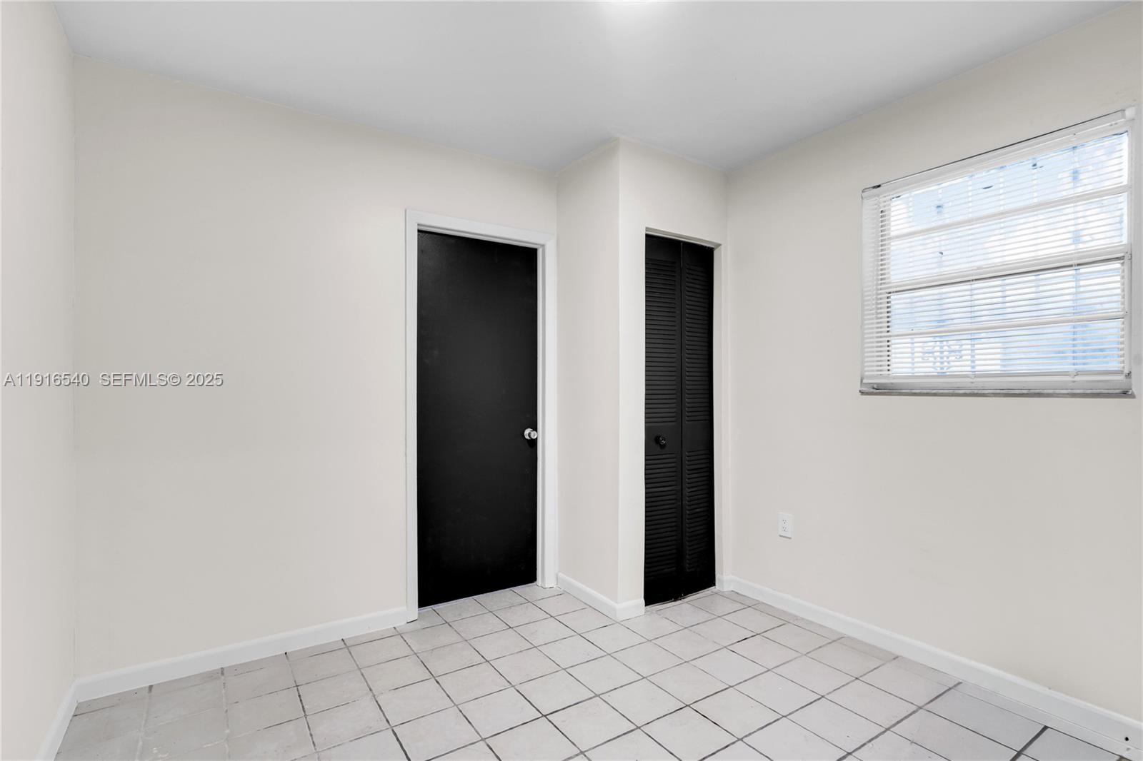 1253 Northwest 44th Street Miami, FL 33142 - Photo 8 of 25 a view of an empty room with window